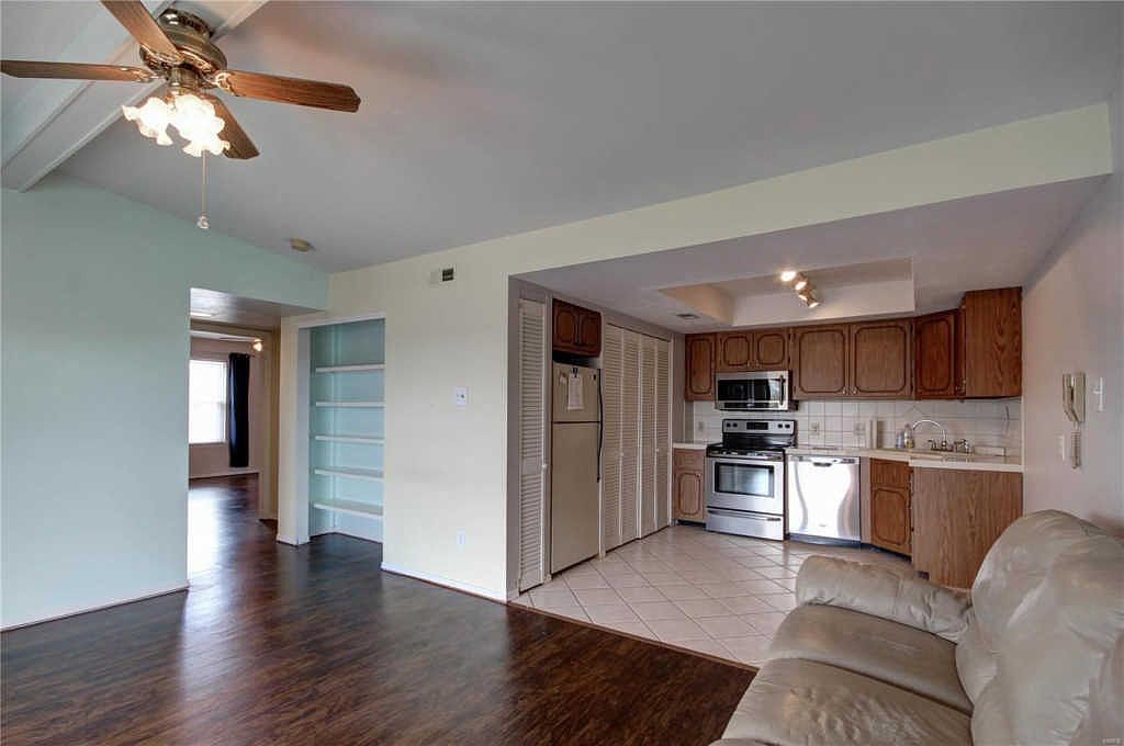 Open living room and kitchen with built-in bookcase and hallway to the bedrooms