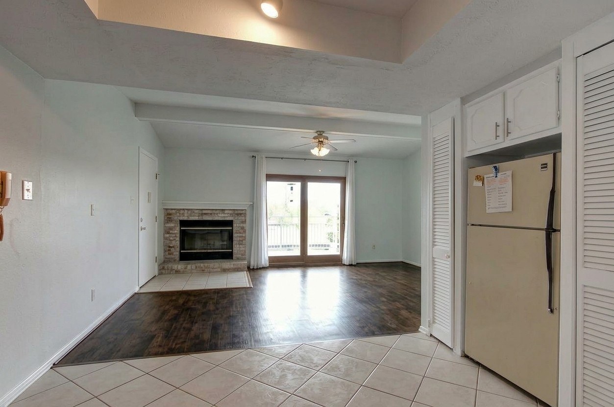 View from the kitchen into the living room, fireplace and deck door